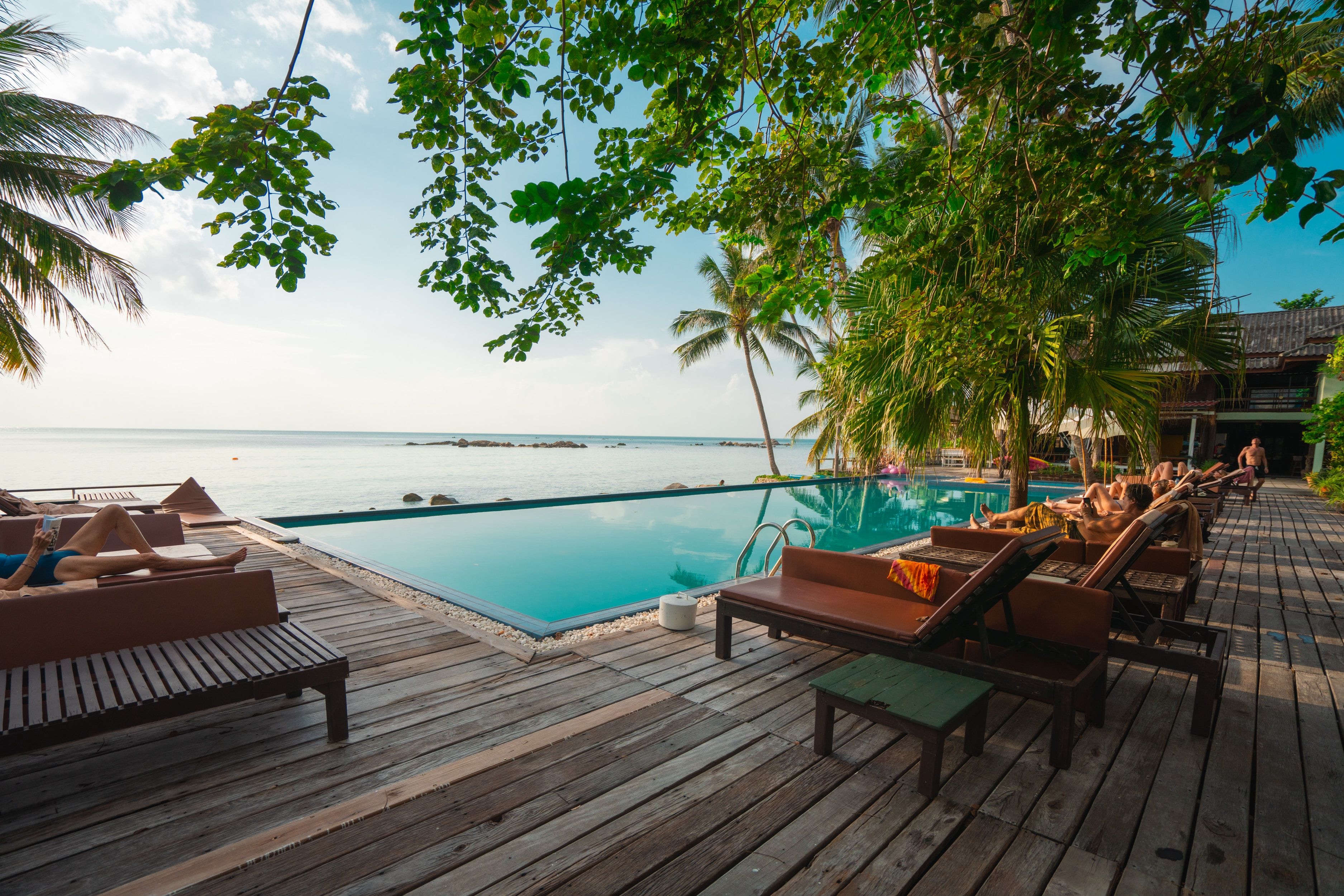 wooden table and chair on wooden deck near body of water