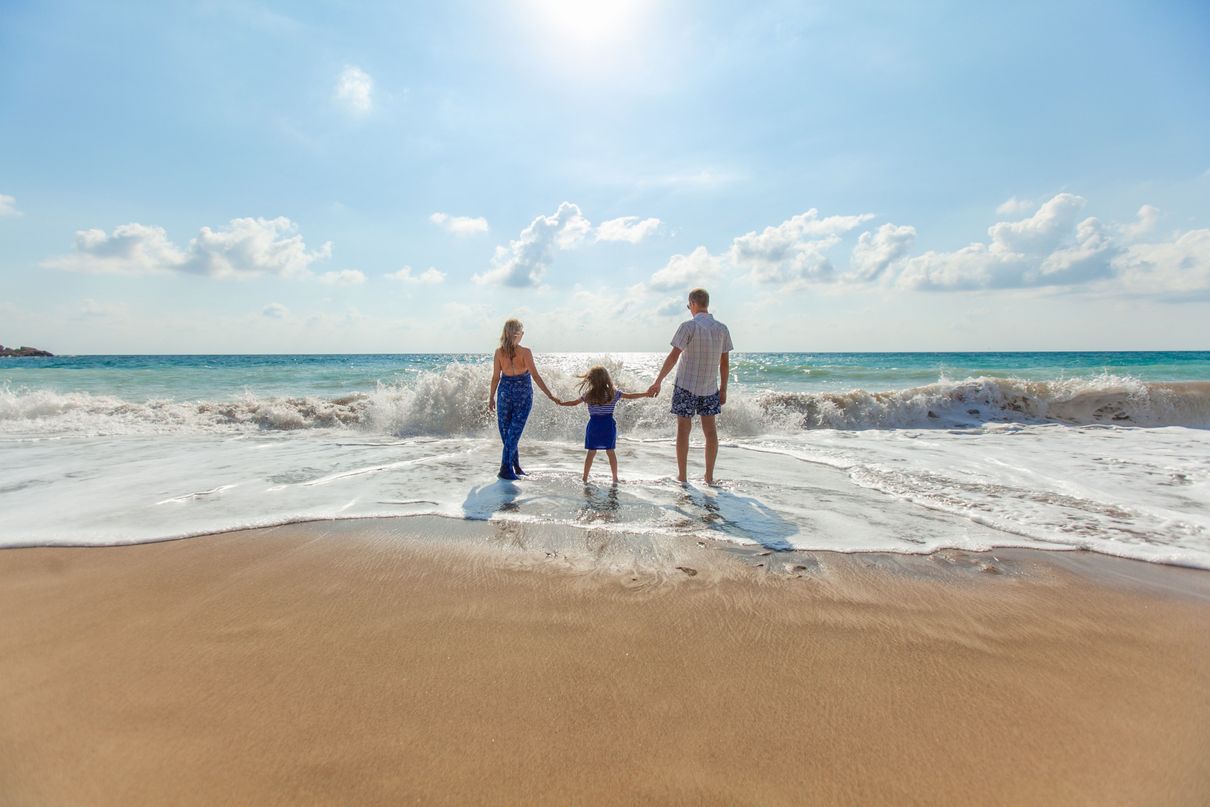 family holding hands in seashore