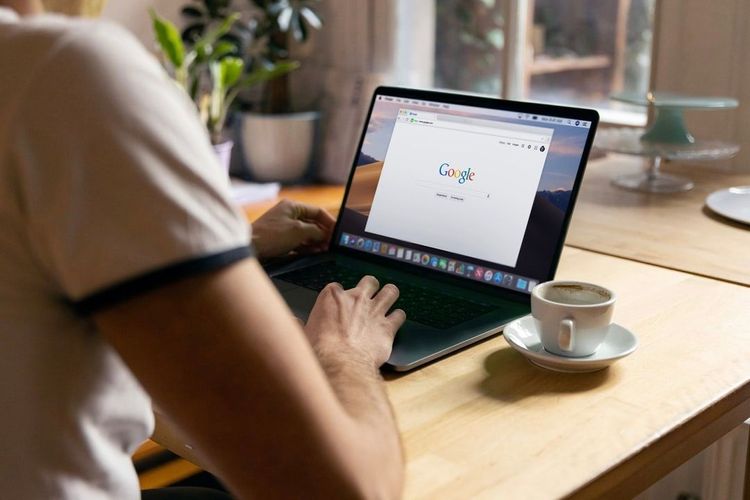 Person using a computer on a coffee table to search google flights