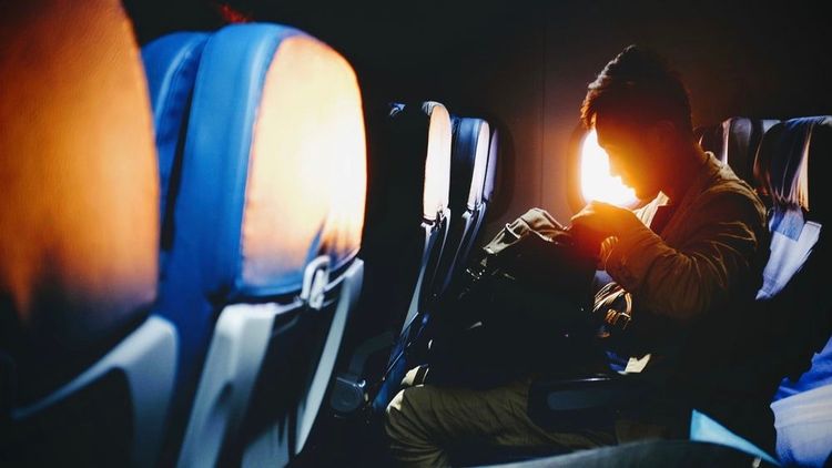 Person looking through a bag on an airplane