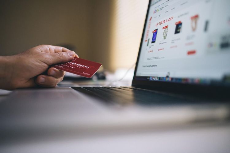 Someone looking at their card and their computer